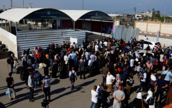 Palestinians gather at the Rafah border crossing on 16 October 2023.