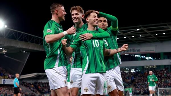 Dion Charles is co<em></em>ngratulated by his Northern Ireland team-mates after scoring from the penalty spot